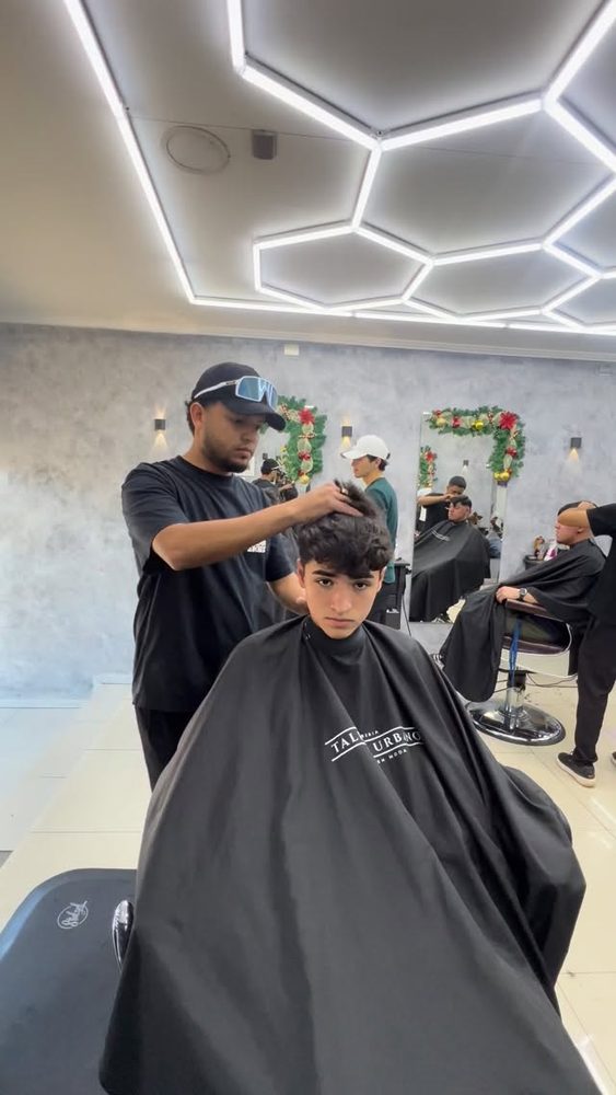 Barbero de Talento Urbano atendiendo a un cliente